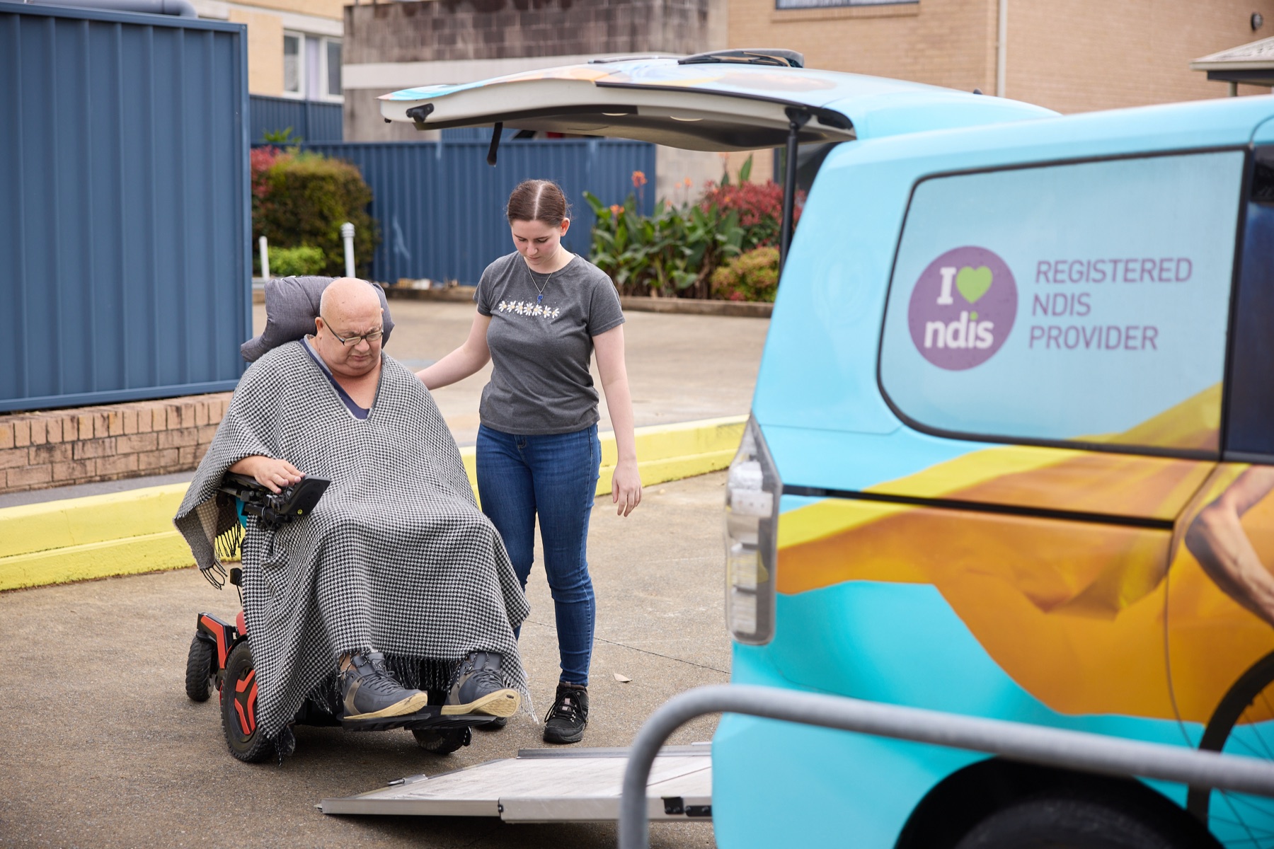 Participant boarding the van via the rear ramp with support